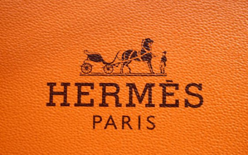 Logo Hermes cùng tên của người sáng lập Thierry Hermes, màu cam chủ yếu và cỗ xe ngựa